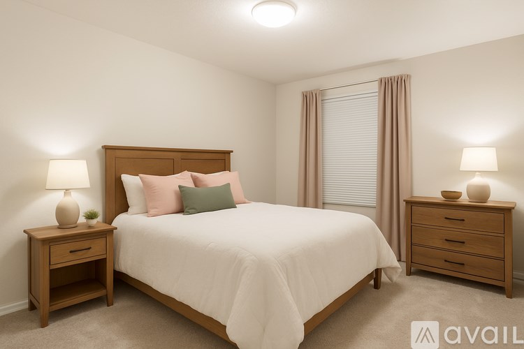 A bedroom with a bed, nightstands, and lamps.