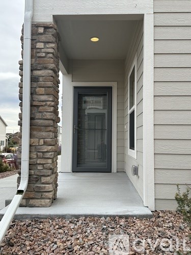 A house entrance with a glass door and a stone pillar.