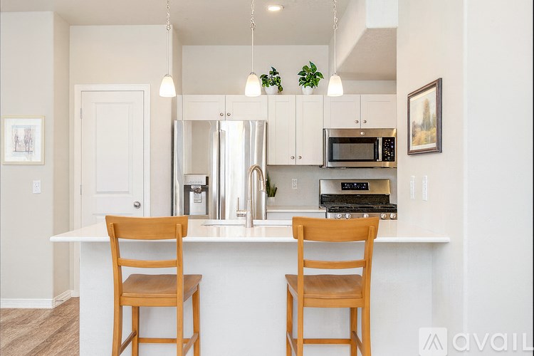 Two wooden chairs are placed in front of a white counter.