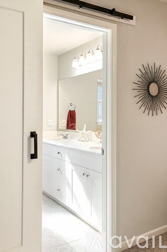 A bathroom with a mirror, sink, and a wall decoration.