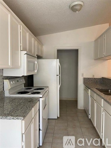 A kitchen with white appliances and cabinets.