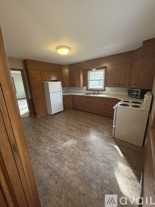 A kitchen with a white fridge and a white washing machine.