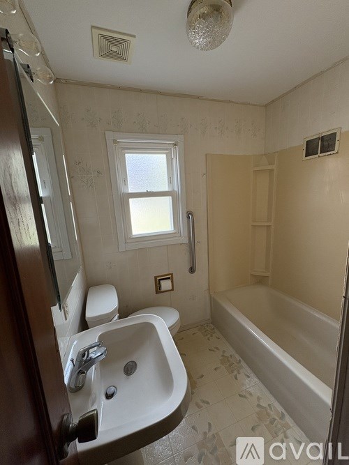 A bathroom with a white sink and a window.