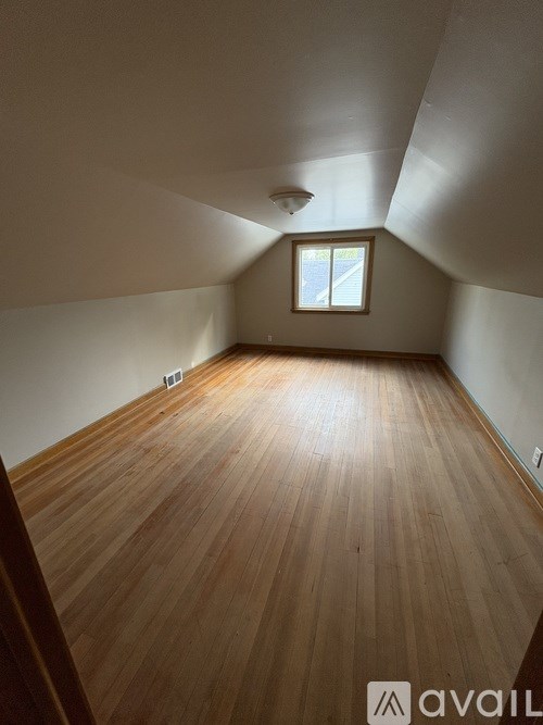 A room with wooden flooring and a window.