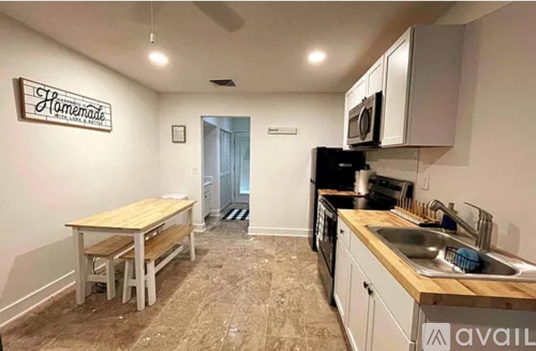 A kitchen with a wooden table and a sign that says "Homemade" on the wall.