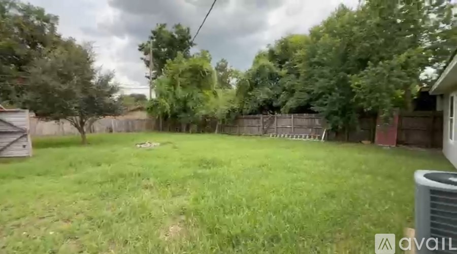 A backyard with a fence and trees.