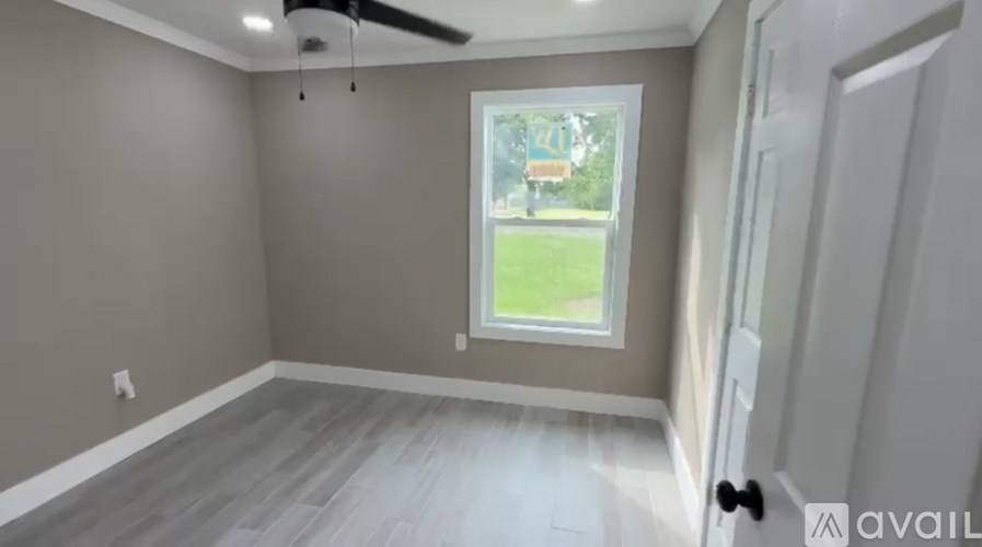 A room with a window and a ceiling fan.