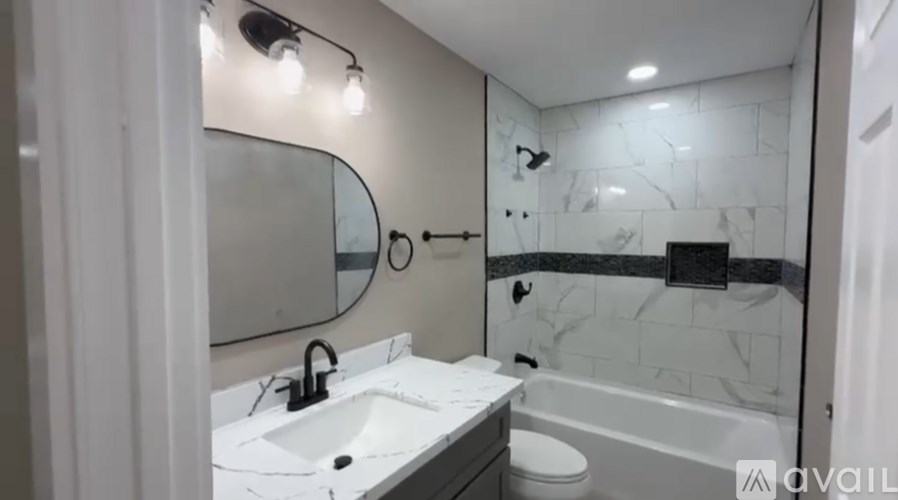 A bathroom with a marble wall and a white sink.