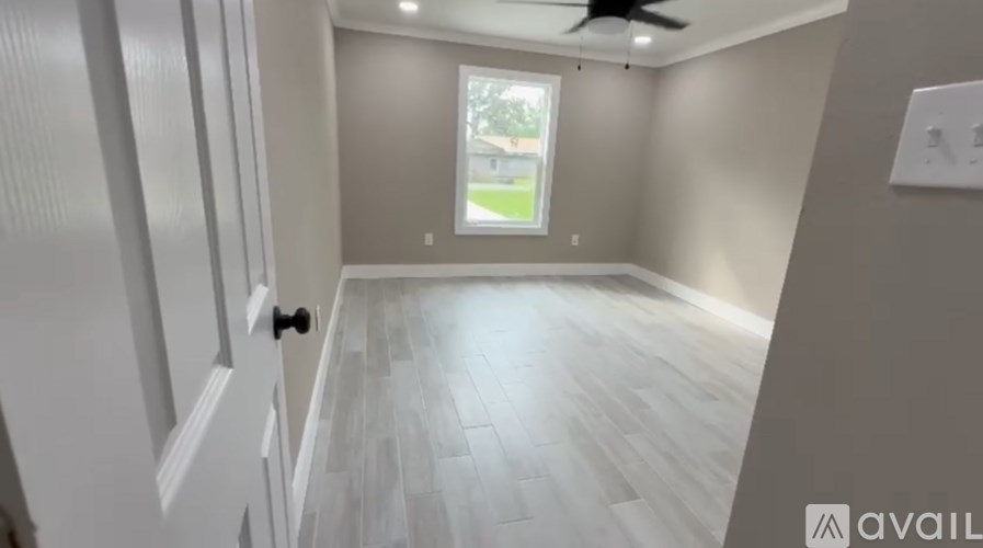 A room with a wooden floor and a window that lets in natural light.