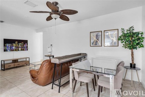 A living room with a brown leather chair and a glass table.