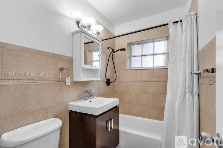 A bathroom with a white tub and a brown cabinet.