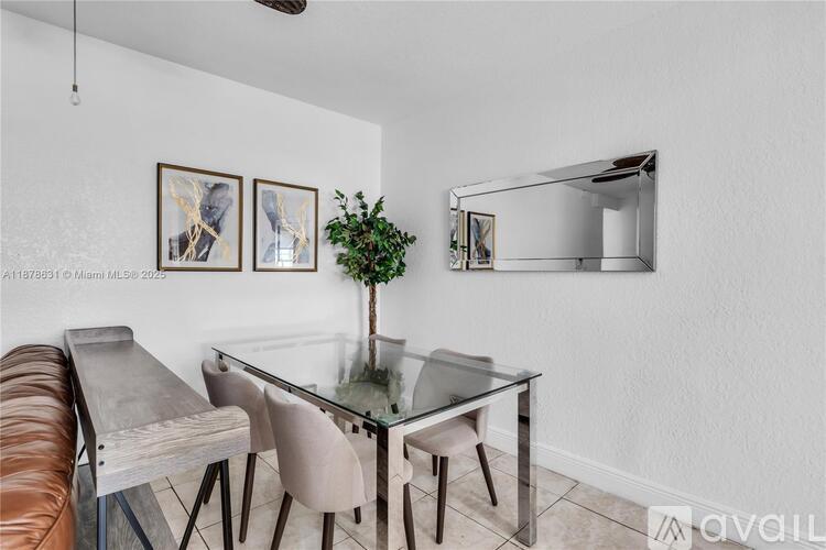 A modern dining room with a glass table and chairs.