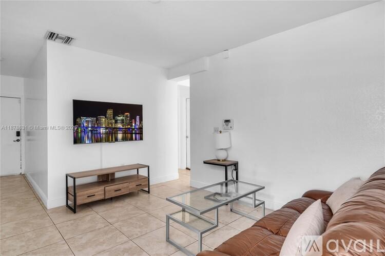 A living room with a brown couch, a glass coffee table, and a painting on the wall.