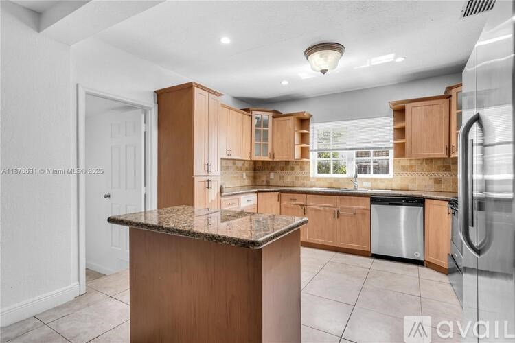A kitchen with wooden cabinets and a granite countertop.