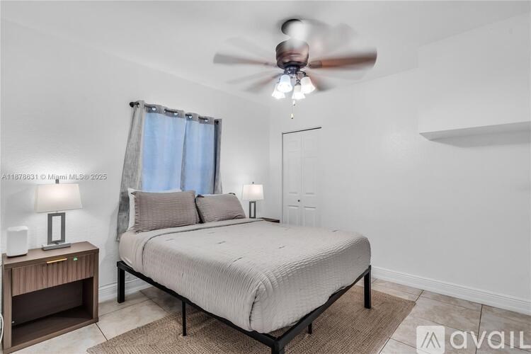 A bedroom with a bed, nightstand, and a ceiling fan.