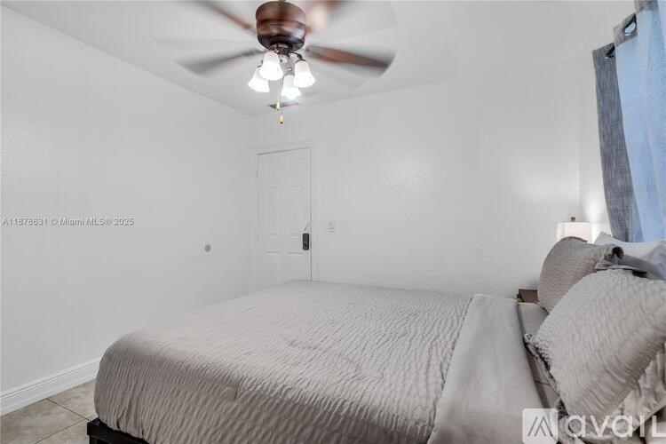 A bedroom with a bed, pillows, and a ceiling fan.