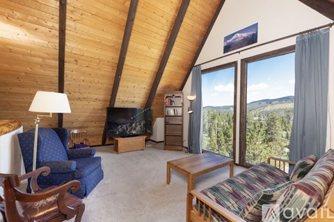 A living room with a blue chair and a wooden table.