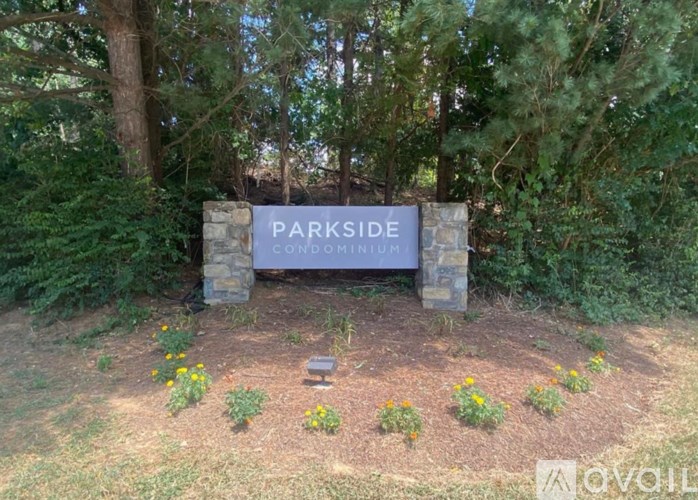 A stone sign that says Parkside in front of trees.