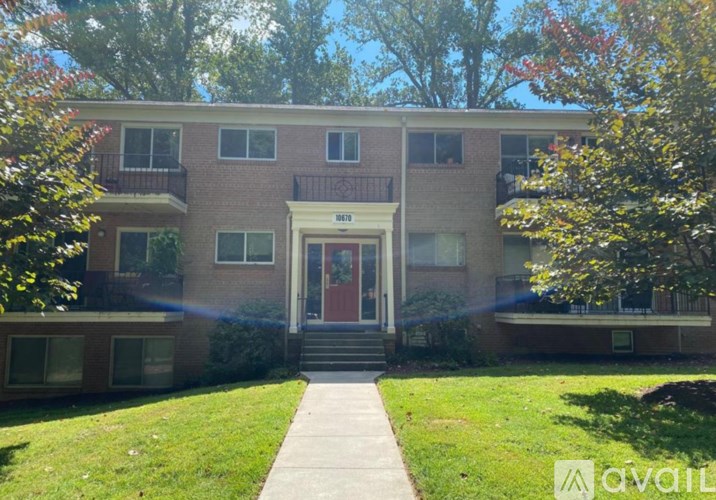 A brick building with a red door and a sign that says "AVAILABLE" on the front.