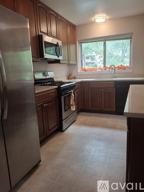 A kitchen with a stainless steel refrigerator, microwave, and oven.