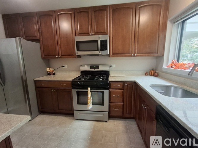 A kitchen with brown cabinets and a stove top oven.