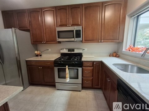 A kitchen with brown cabinets and a stove top oven.