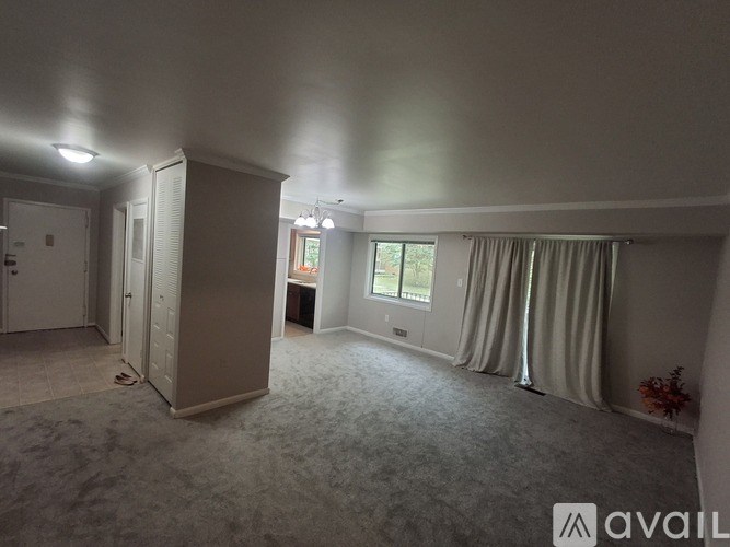 A room with a large window and a carpeted floor.