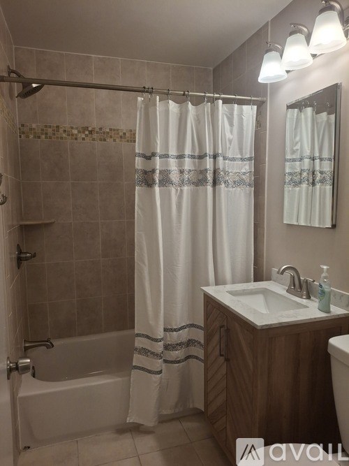 A bathroom with a white shower curtain and a white sink.