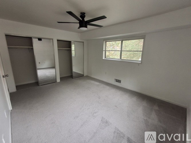 A room with a ceiling fan and a window.