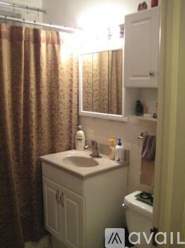 A bathroom with a sink, toilet, and a mirror.