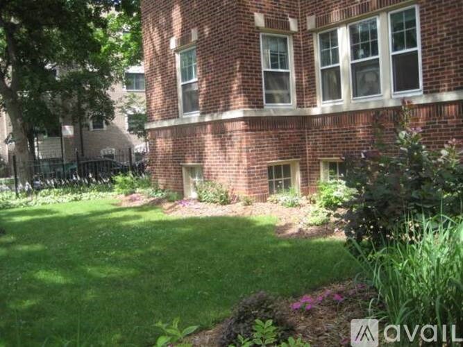 A red brick building with a green lawn in front.