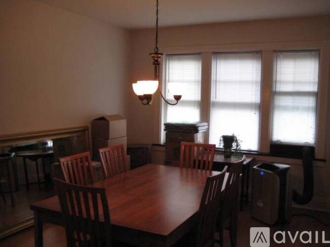 A dining room with a wooden table and chairs.