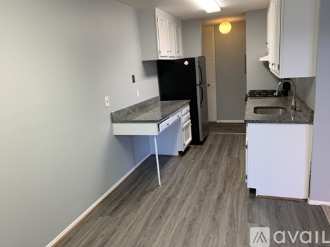 A kitchen with a black fridge and a table with a white tablecloth.