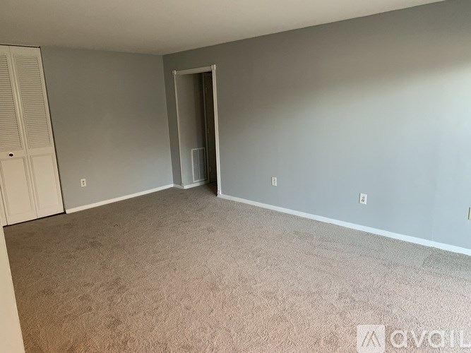 A room with beige carpet and a white door.