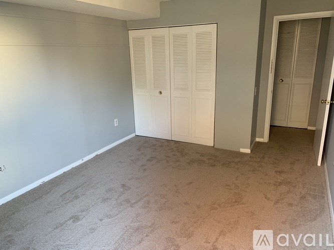 A room with a carpeted floor and a white door.