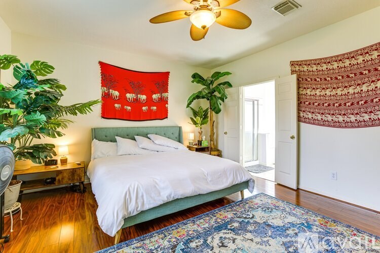 A bedroom with a green headboard and a white bed.