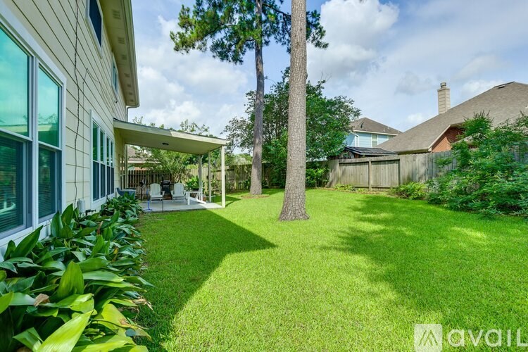A house with a well-maintained lawn and a tree in the yard.