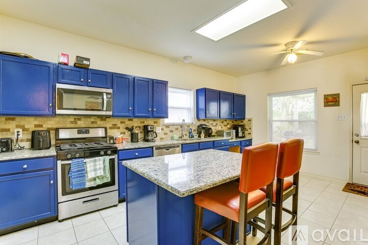 A kitchen with blue cabinets and a granite countertop.
