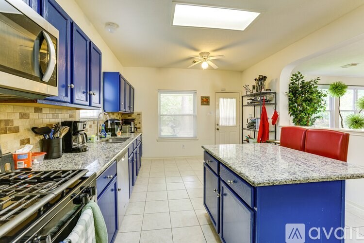 A kitchen with blue cabinets and a granite countertop.