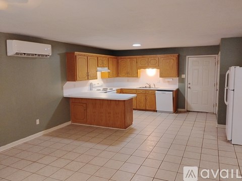 A kitchen with white appliances and wooden cabinets.