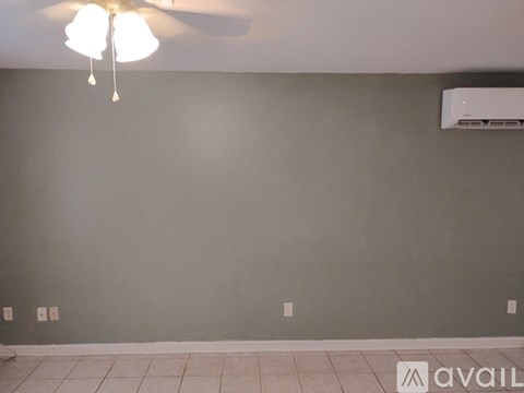 A room with a ceiling fan and an air conditioner unit on the wall.