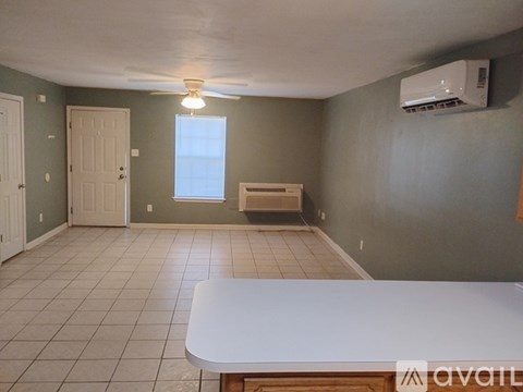 A room with a white table and a window with a view of the outside.