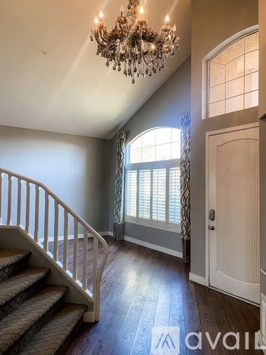 A chandelier hangs over a staircase in a home.