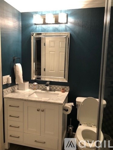 A white toilet sits next to a sink in a bathroom.