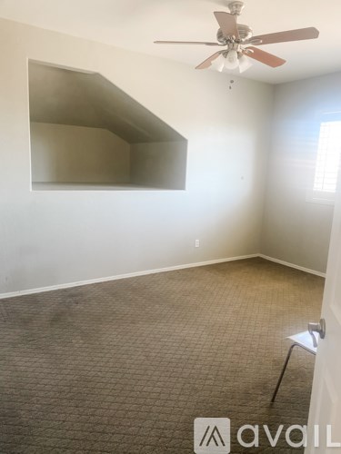 A room with a ceiling fan and a carpeted floor.