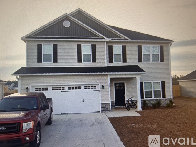 A house with a red truck parked in front.