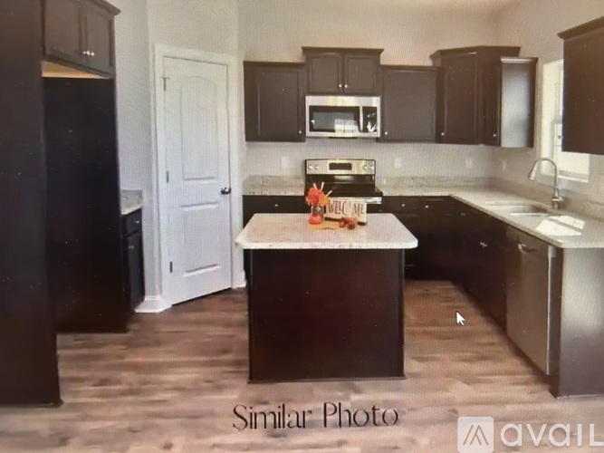 A kitchen with dark wood cabinets and a white door.