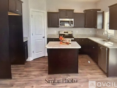 A kitchen with dark wood cabinets and a white door.