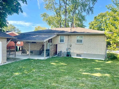 A house with a covered patio and a lawn.
