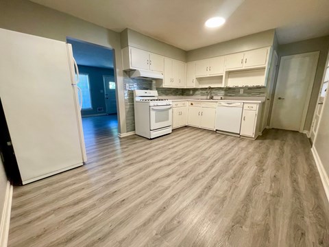 A kitchen with white appliances and cabinets.